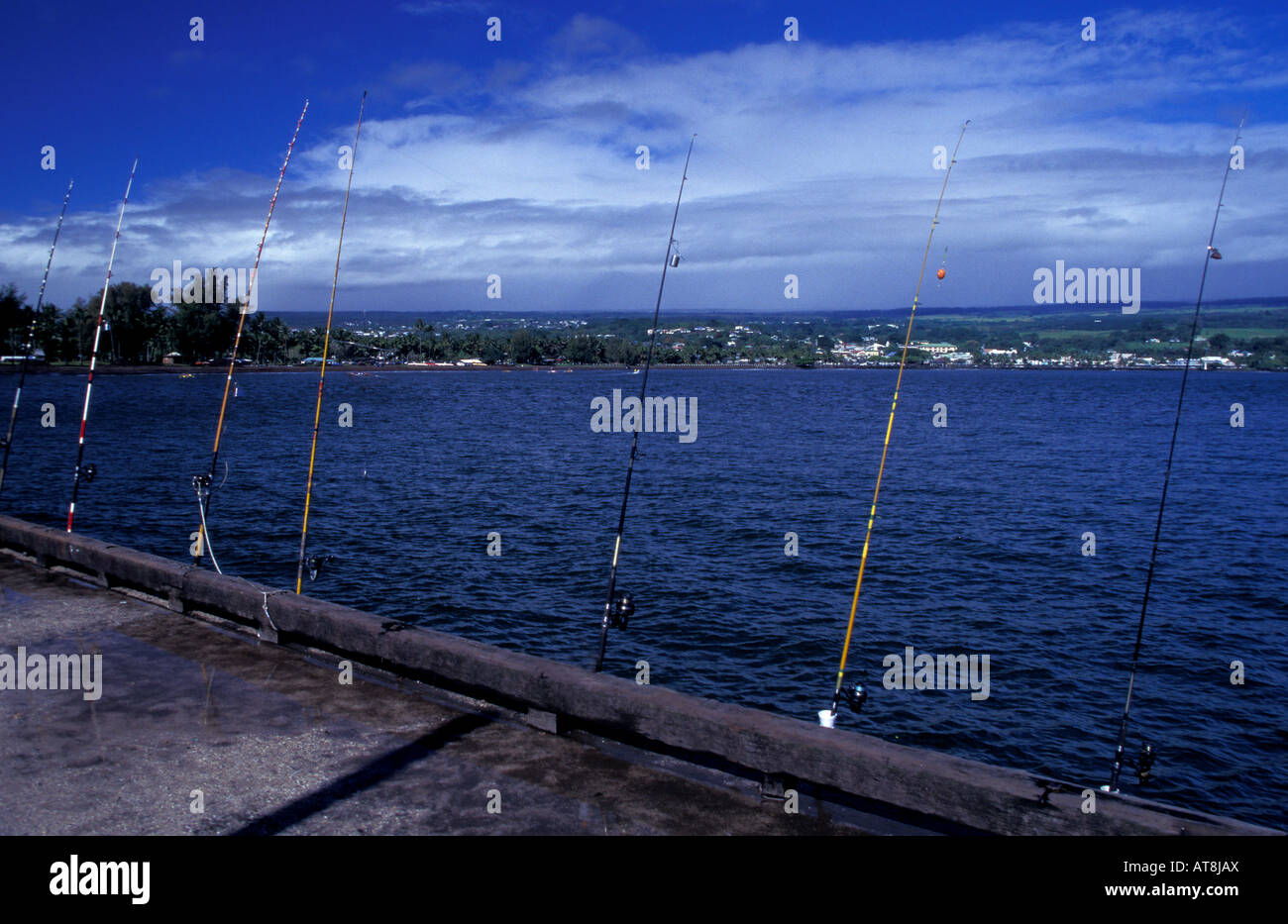Angelruten bei Hilo Warf mit Aussicht auf Stadt, Big Island von Hawaii Stockfoto