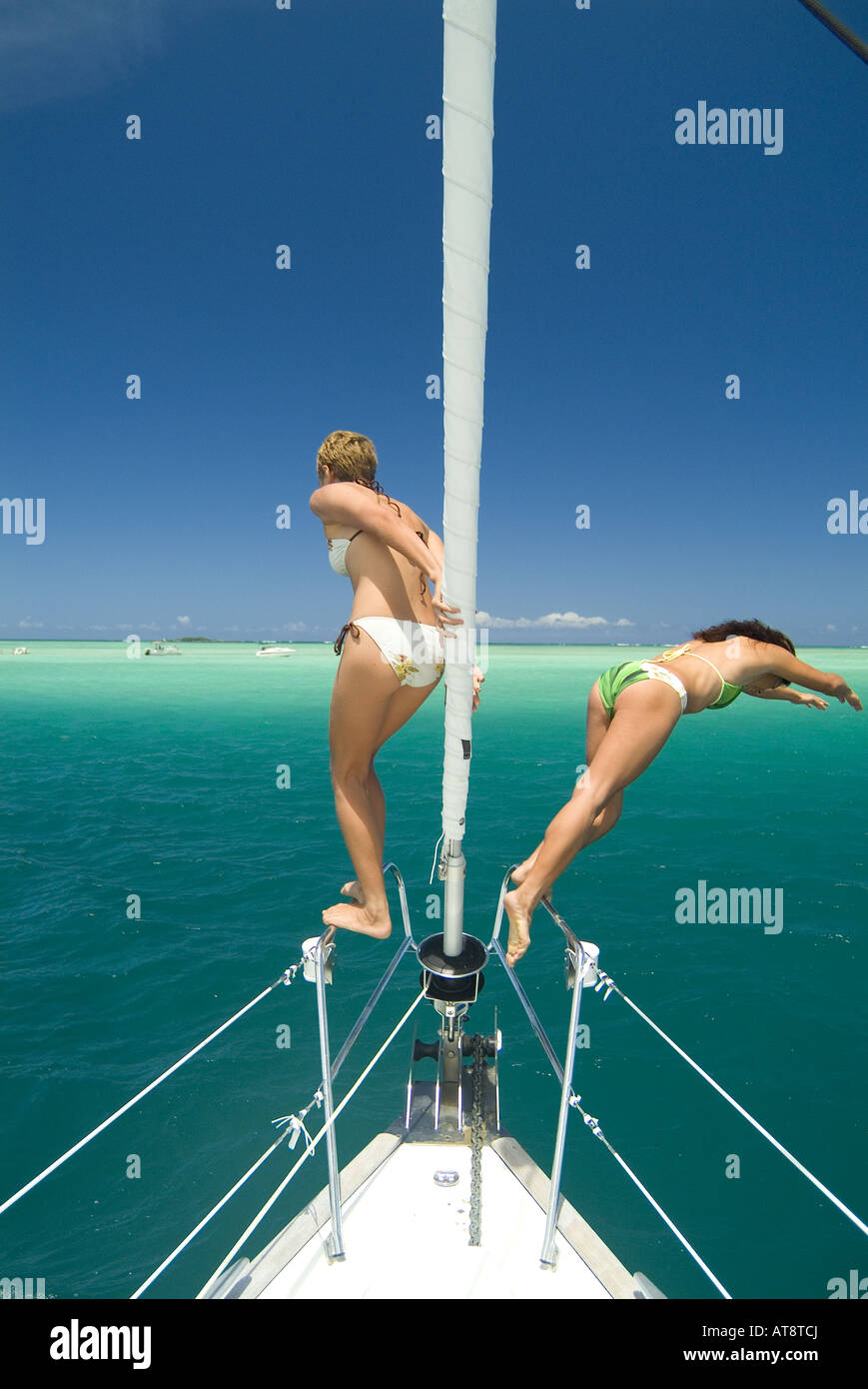 Zwei junge Frauen Tauchen Sie ein in das brillante türkisblaue Wasser der Kaneohe Bay mit wunderschönen Ahu O Laka Sandbank im Hintergrund. Stockfoto