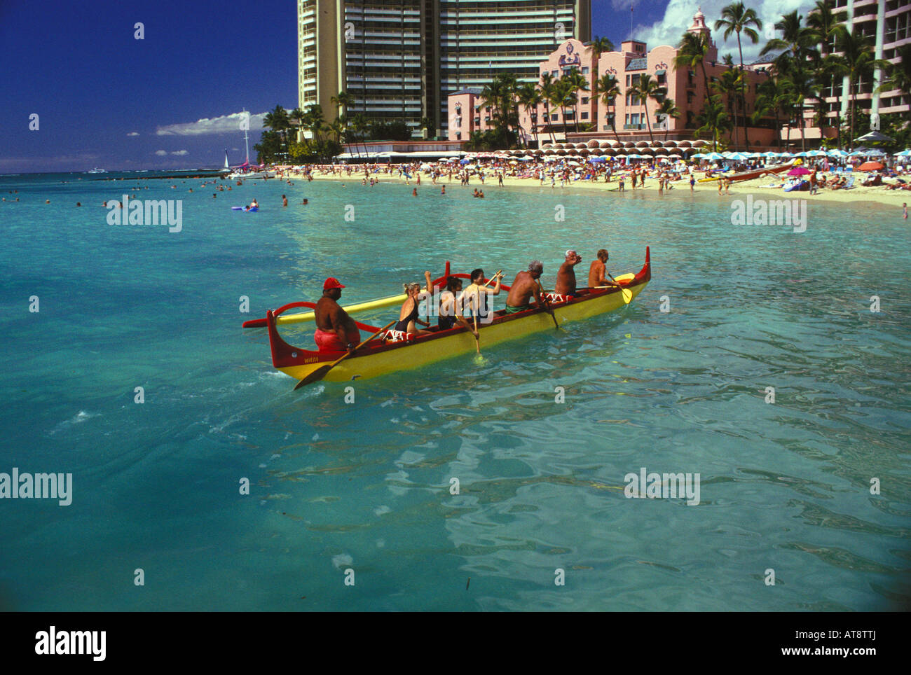 Touristen, die paddeln ein Auslegerkanu aus berühmten Strand von Waikiki, mit dem Royal Hawaiian Hotel im Heck, Oahu Stockfoto
