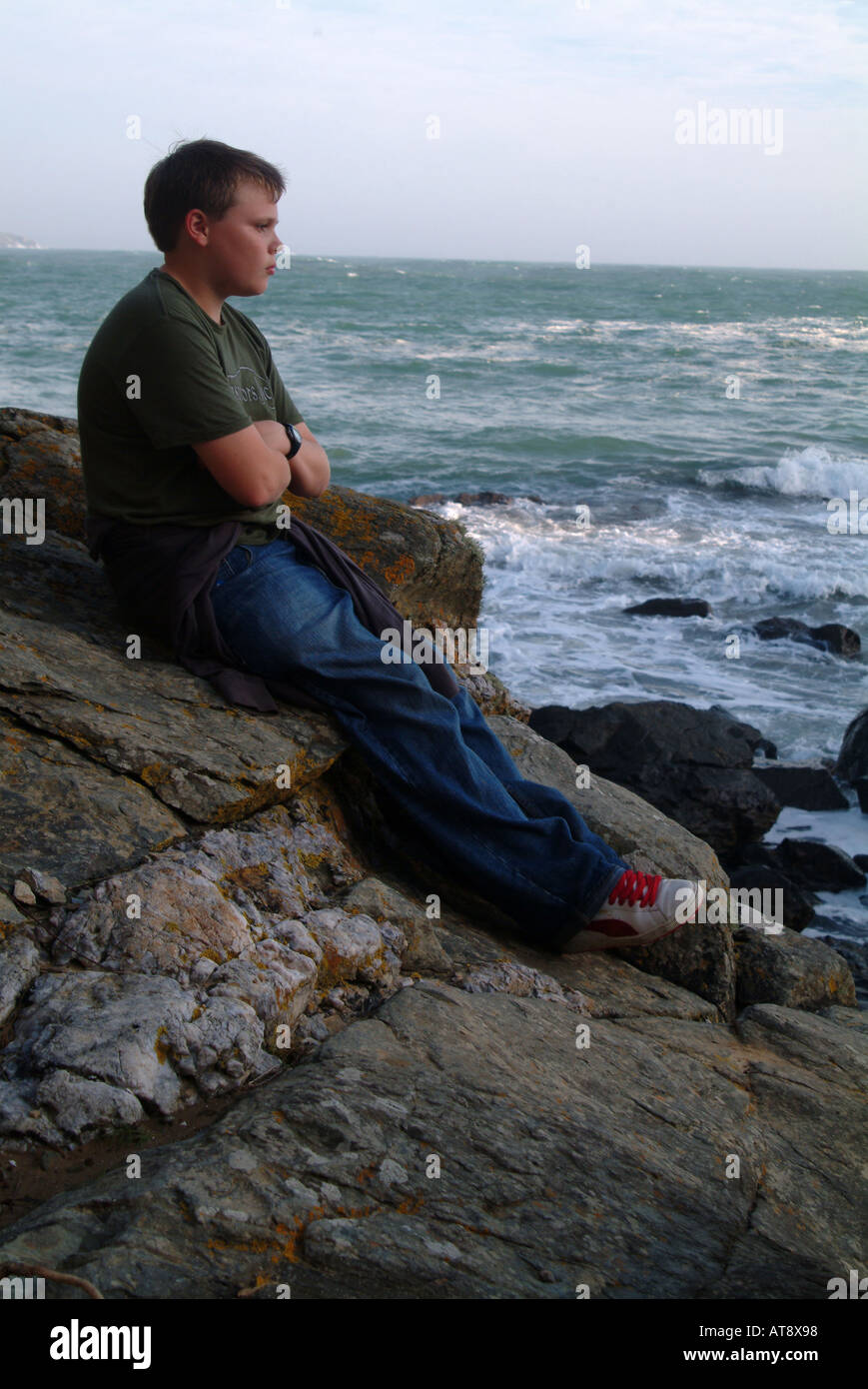 Teenager auf einem Felsen sitzen und Blick auf die Adria Stockfoto