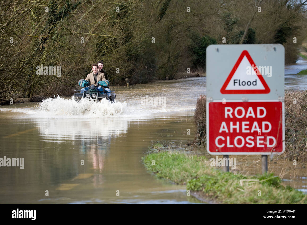 Zwei Jungs auf einem Quad fahren die B4213 an, während sie wegen Überschwemmungen in der Nähe von Apperley, Gloucestershire, Großbritannien im März 2007 geschlossen war Stockfoto
