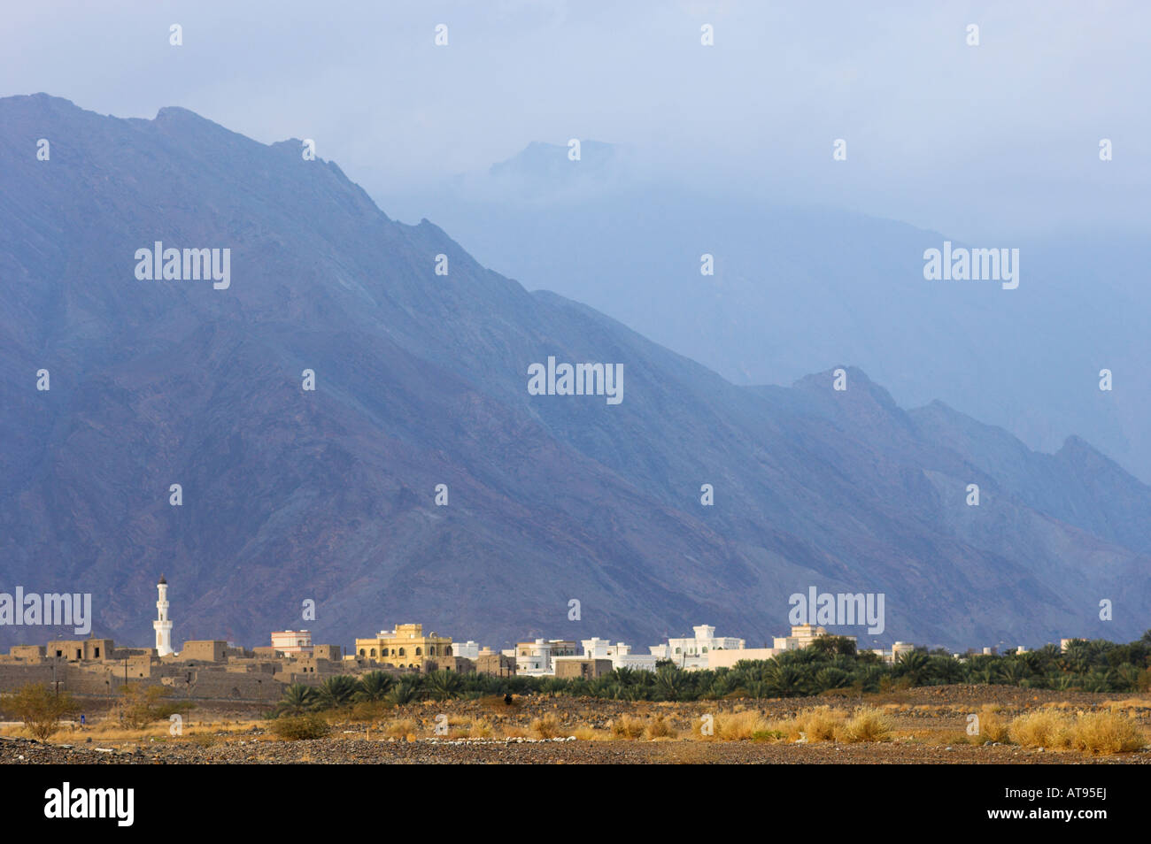 Blauen dunstigen Berge über Wadi und Stadt von Birkat Al Mawz Oman Stockfoto