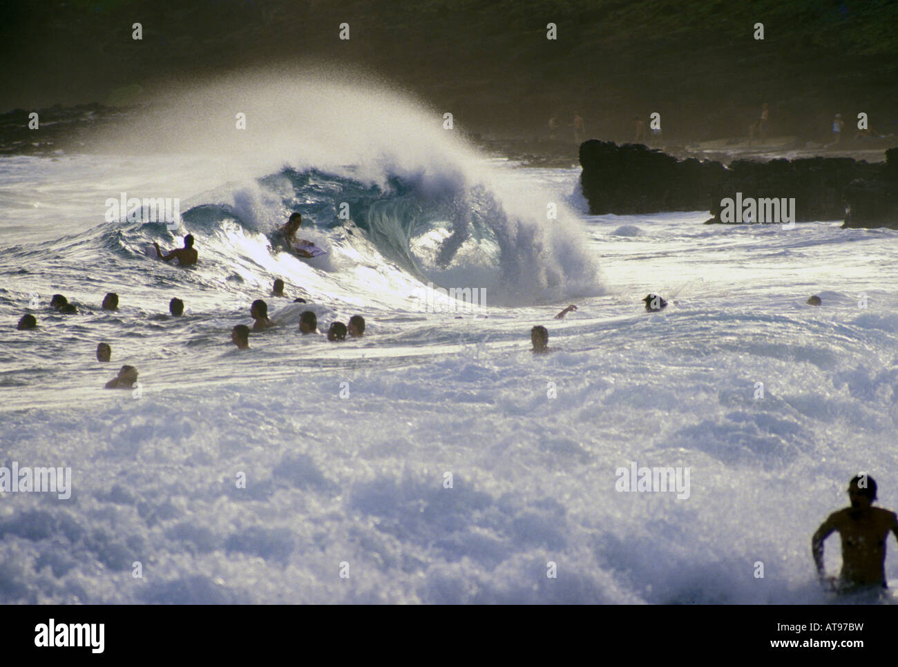 Sonniger Tag, große Gruppe von Körper Surfer & Boarder auf große brechende Welle. Sandy Beach, Oahu Ufer Ost Kaiwi Küste, Hawaii Stockfoto