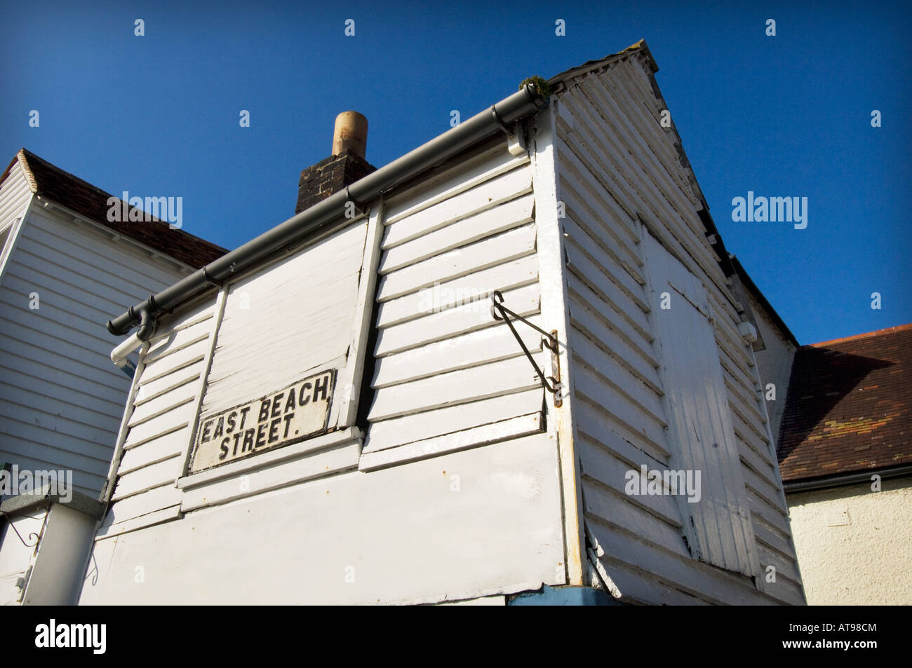 Ein kleines Holzhaus mit Brettern vernagelt für den Winter in East Beach Street direkt am Meer in Hastings East Sussex UK Stockfoto