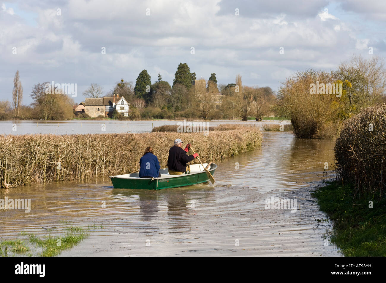 Anwohner, die im März 2007 in einer überfluteten Gasse in der Nähe des Flusses Severn in Deerhurst, Gloucestershire, Großbritannien, mit dem Boot unterwegs waren Stockfoto