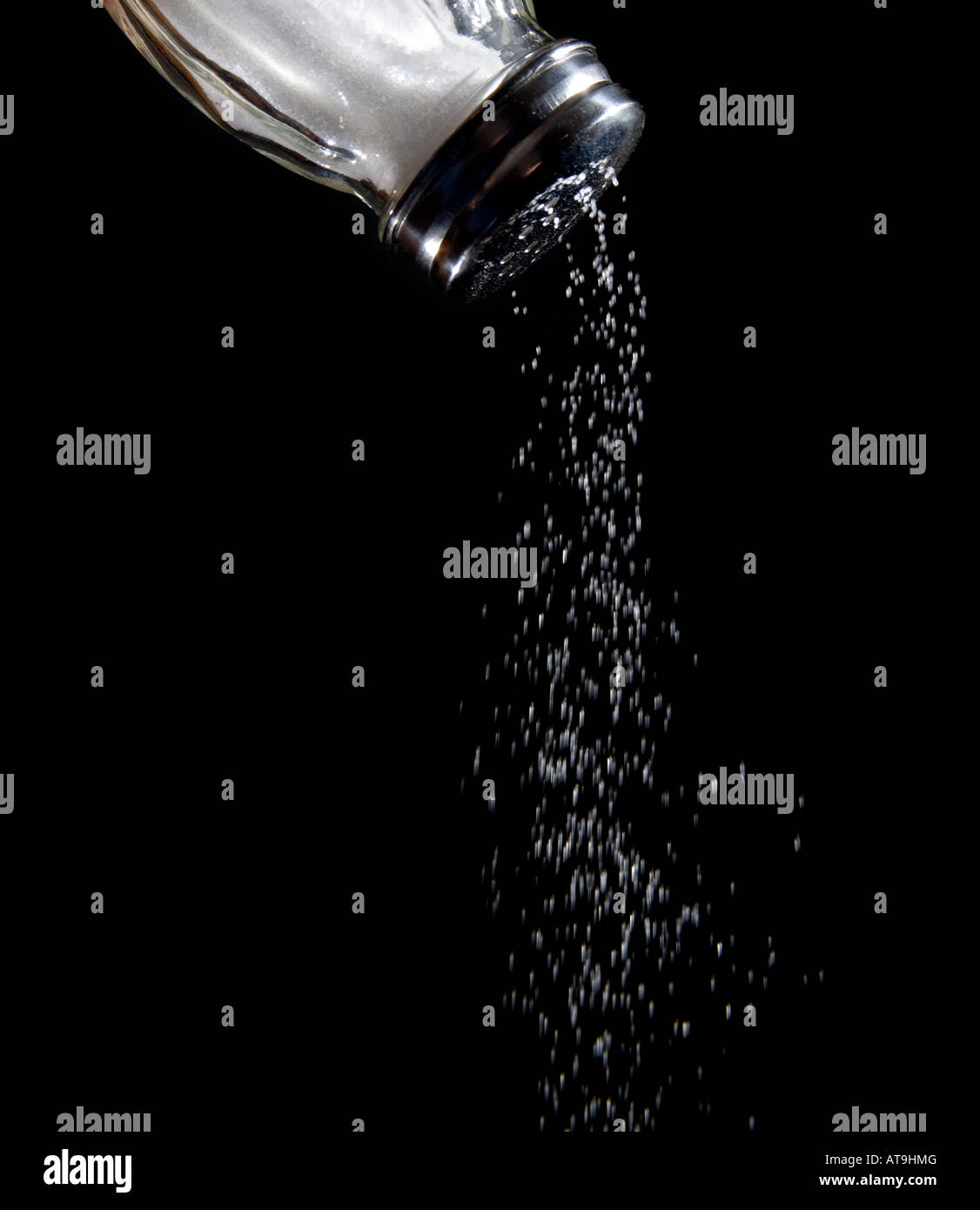 Salzstreuer mit Salz Coming-out Salzstreuer Natrium salzig Herausfallen aus schwarzem Hintergrund Lebensmittel Lebensmittel Stockfoto