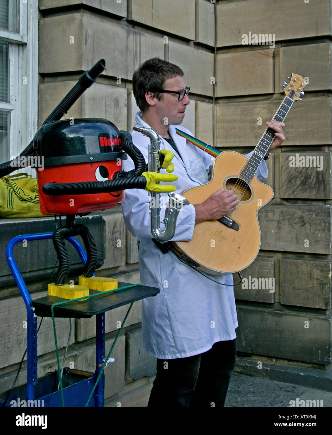 Street Performer spielt Gitarre während am Saxophon begleitet von Vakuum Edinburgh Fringe Festival, Schottland, Vereinigtes Königreich, Stockfoto
