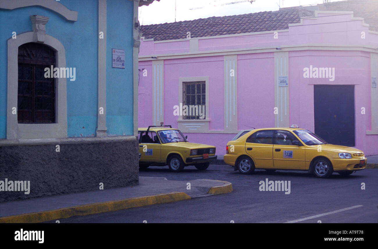 Straßenecke mit rosa und blauen Häusern und gelben taxis Stockfoto