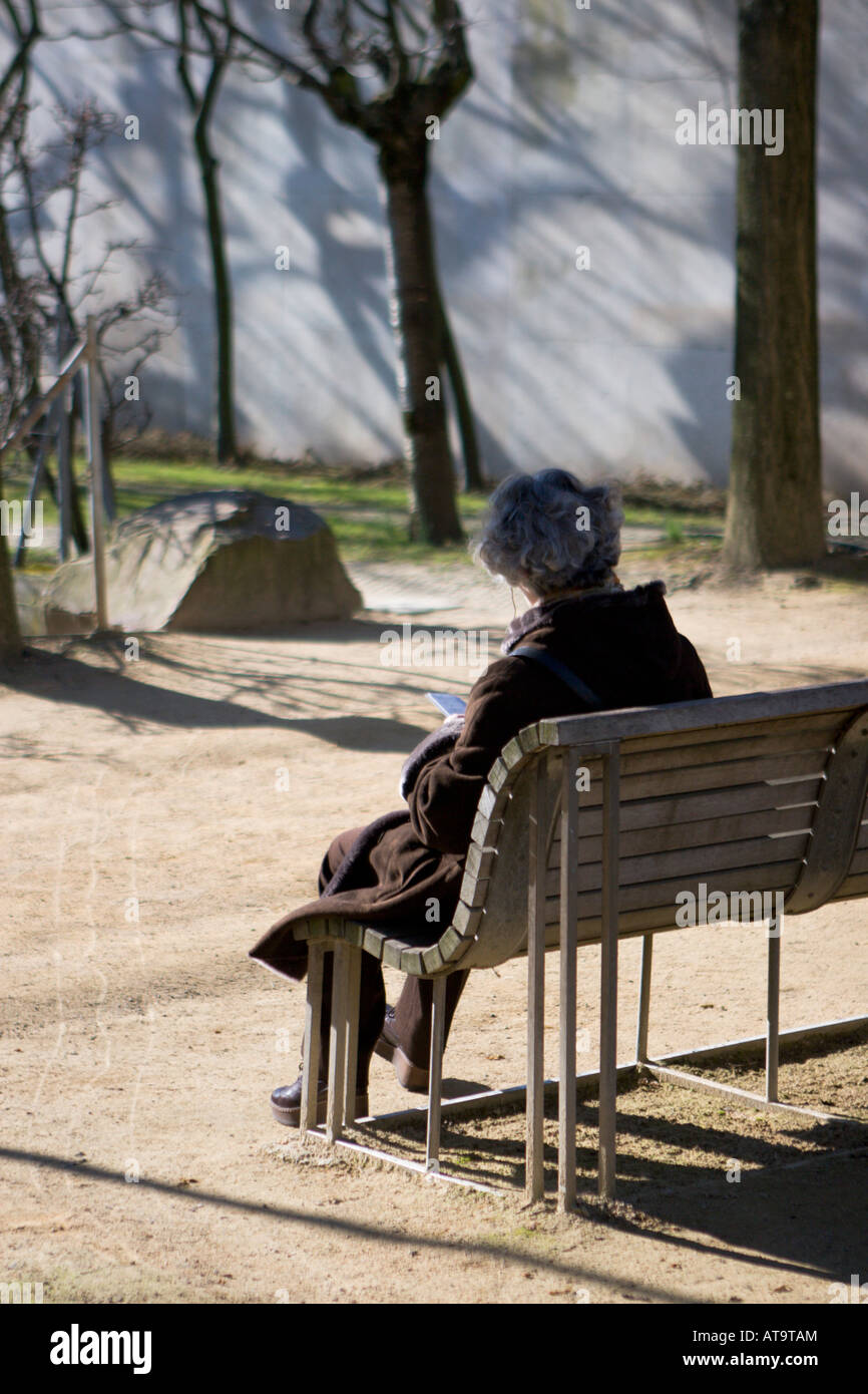 Ältere Frau sitzen auf ihren eigenen in Parc Andre Citroen Stockfoto