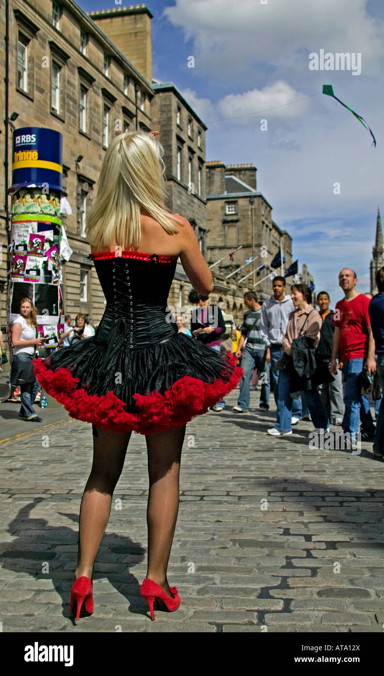 Blonde Frau in Showgirl Outfit gekleidet fliegt einen Kite in Edinburgh High Street während Fringe Festival Stockfoto
