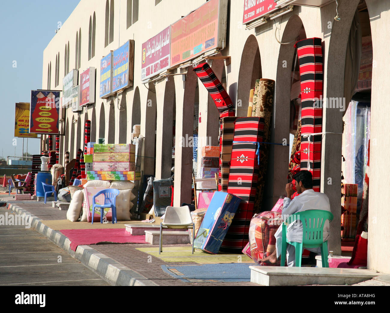 Ein Ladenbesitzer mit seinem Bestand, den Teppich Markt, Abu Dhabi, VAE Stockfoto