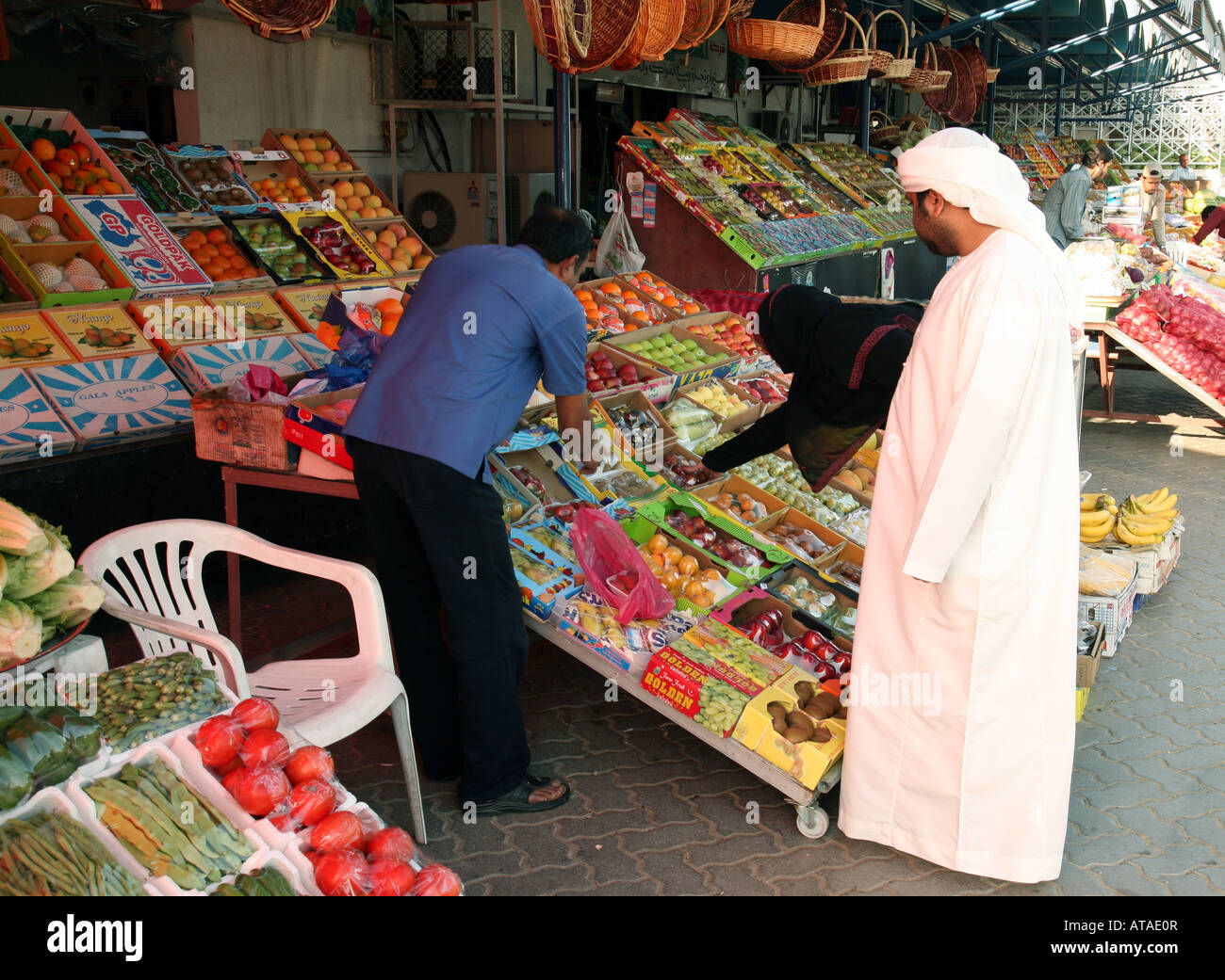 Ein arabisches paar shopping für Obst und Gemüse an einem Marktstand, Stadt Abu Dhabi, Vereinigte Arabische Emirate Stockfoto