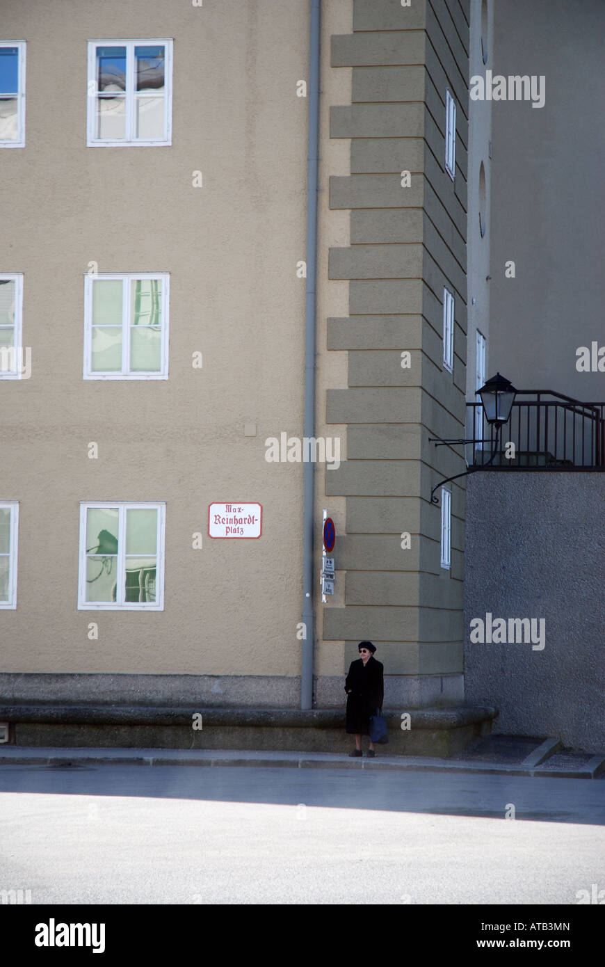 Alte Frau steht auf einer barocken Straßenecke in Salzburg Stockfoto