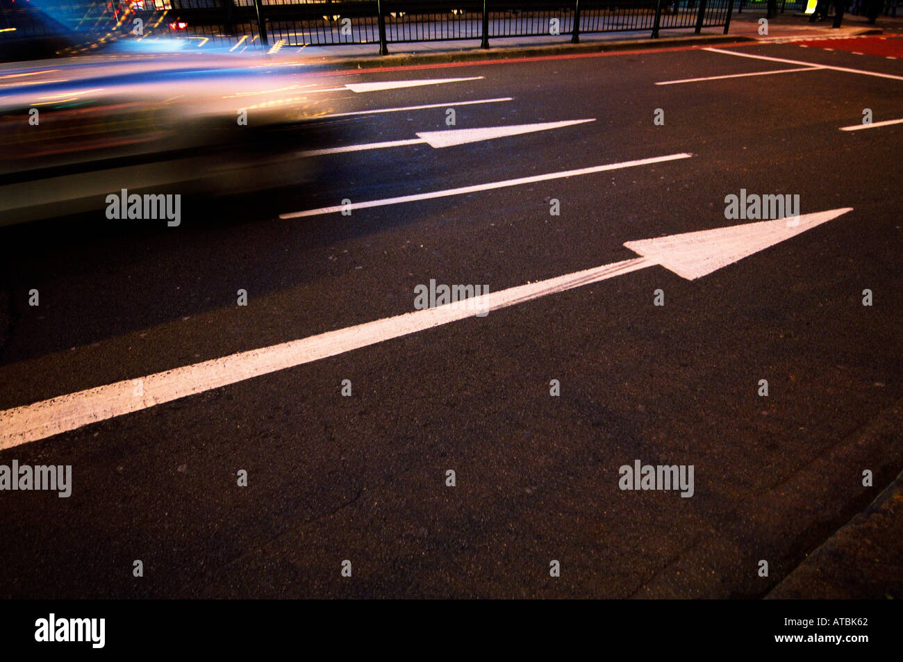 Weiße Straßenpfeile zeigen die Geschwindigkeit des vorbeifahrenden Verkehrs an Stockfoto