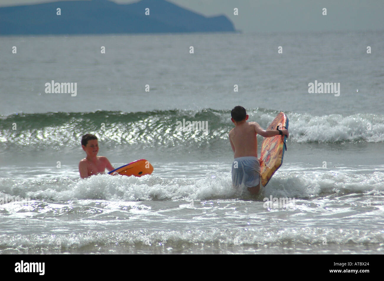 Familie Spielzeit am großen Strand von Zoll Co Kerry wo Autos geparkt werden kann, während Co Kerry Irland-Wellenreiten Wellenreiten Stockfoto