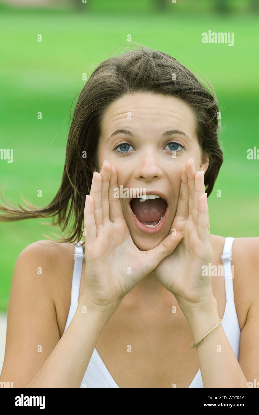 Teenager-Mädchen schreien, Handzeichen, Mund, Blick in die Kamera Stockfoto