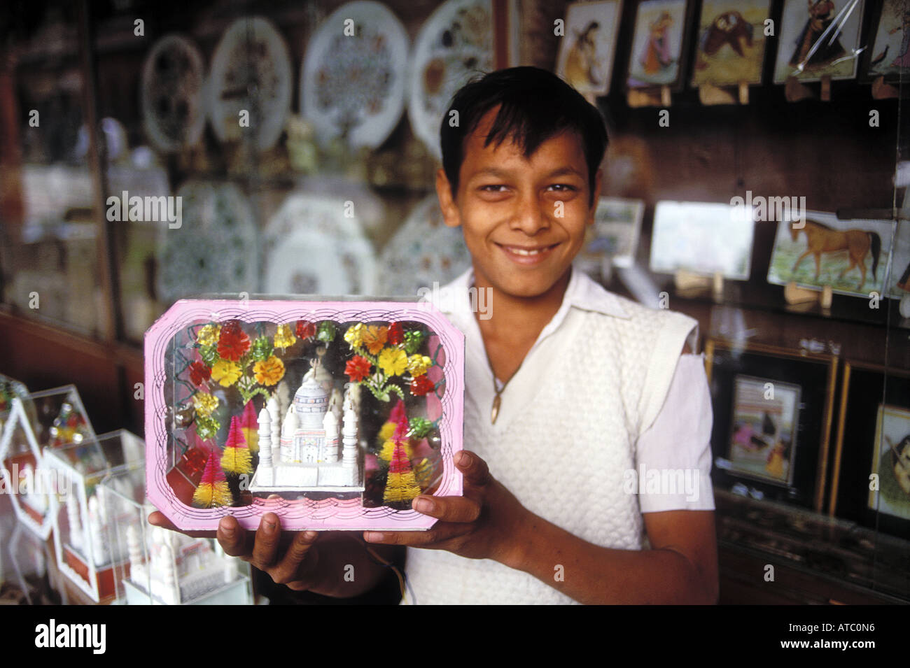 Ein Lächeln auf den Lippen Indianerjunge zeigt ein Modell des Taj Mahal angeboten als Andenken an einen Besuch Stockfoto