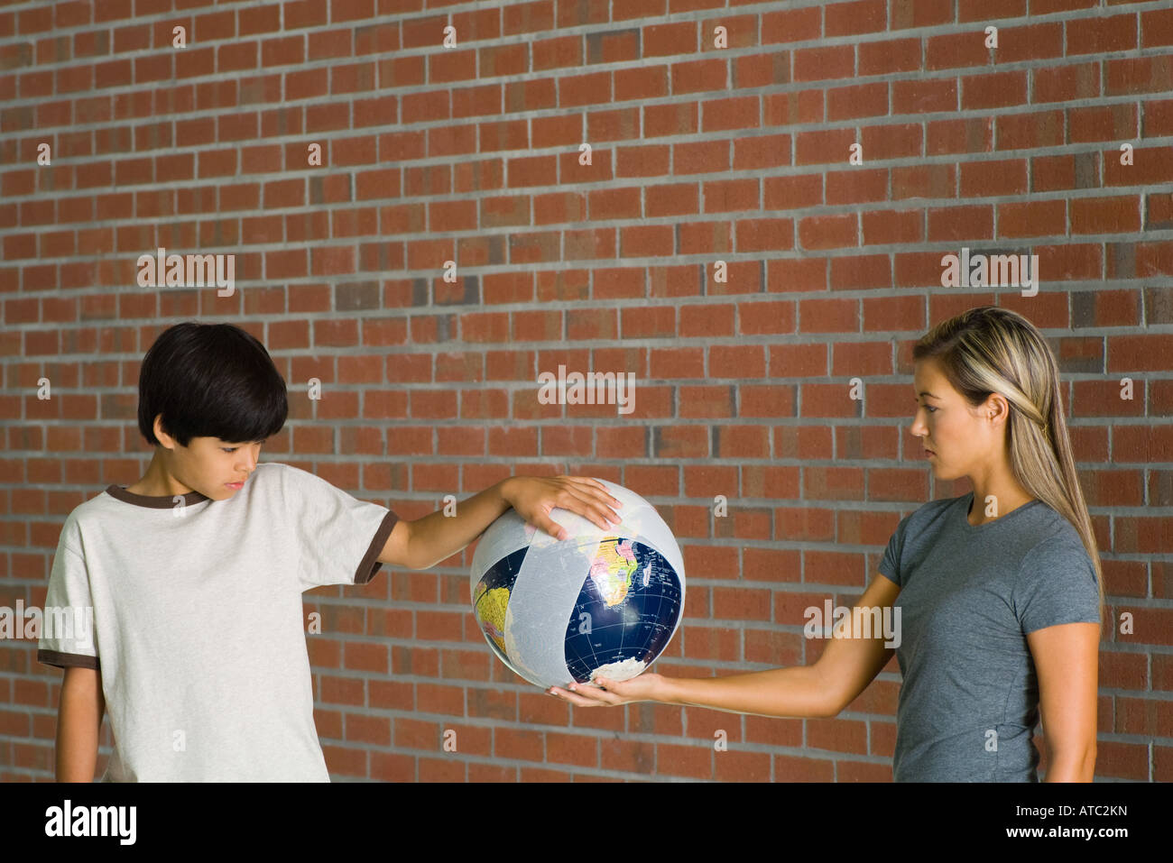 Junge und Frau hält bandagiert Globus zusammen Stockfoto