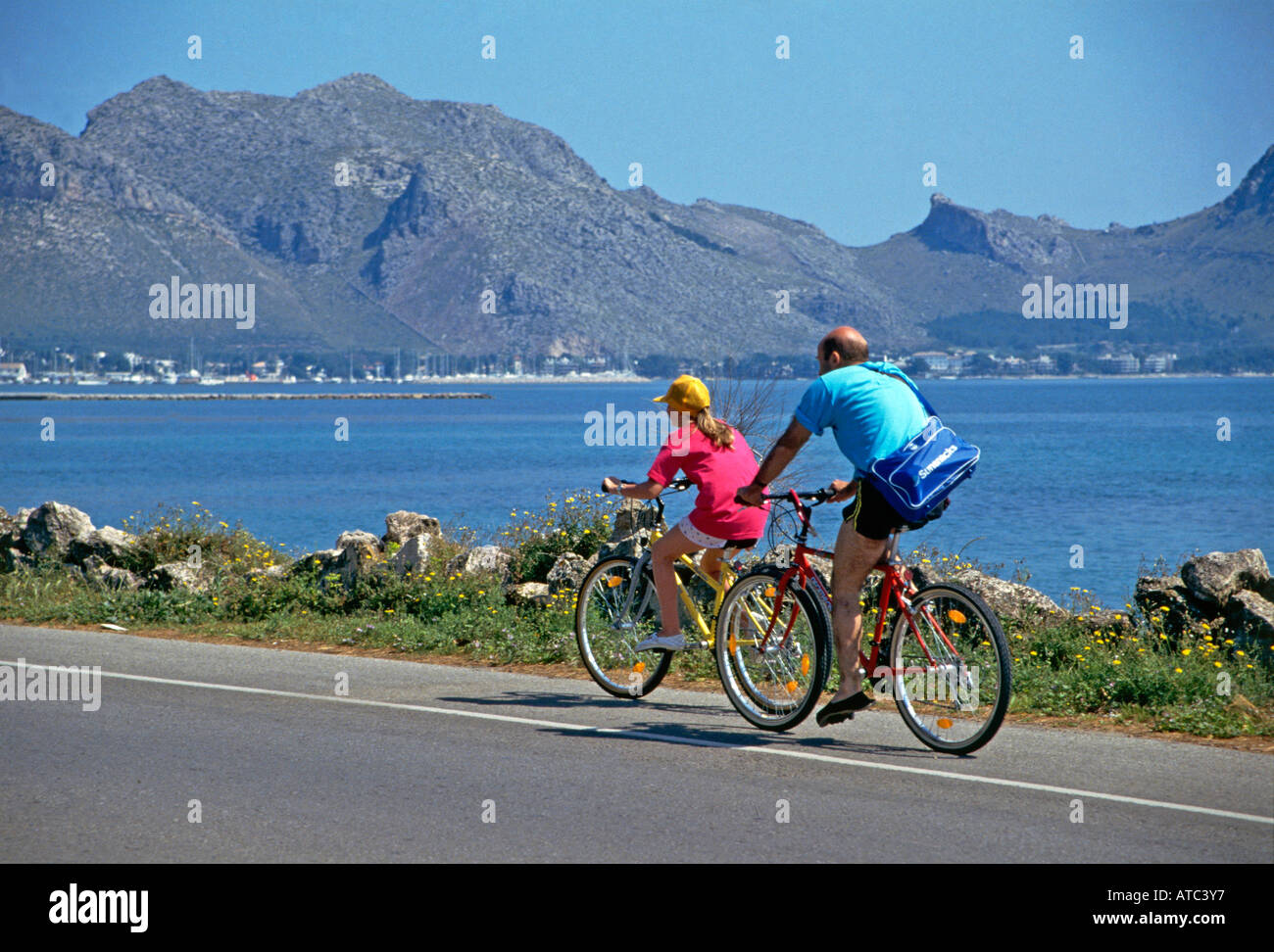 Urlauber, Radfahren und genießen die Aussicht von der Küstenstraße in der Nähe der Ortschaft Port de Pollenca umgeben von Hügeln und liegt an der Mündung der Bucht von Pollenca Stockfoto