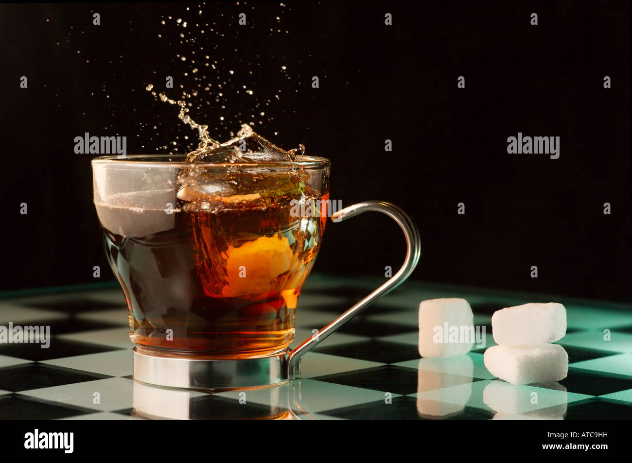 Ein Stück Würfelzucker in einer Tasse Tee gelöscht wird. Stockfoto