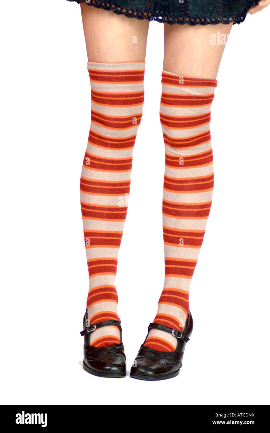 junge Frau s Beine tragen gestreifte weiß orange Länge Kniestrümpfe und schwarze Schuhe, isoliert auf weiss Stockfoto