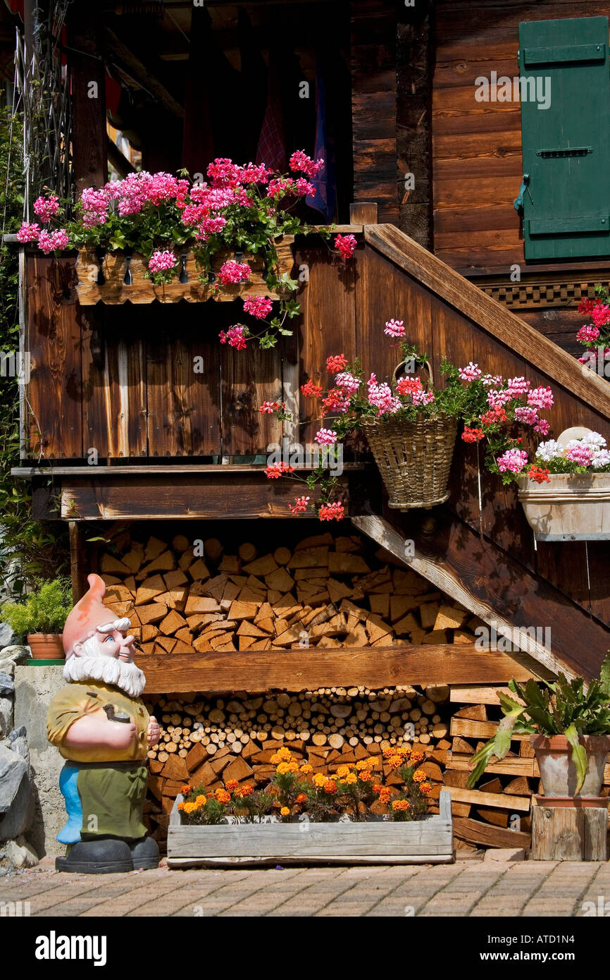 Gartenzwerg steht durch Treppe bergende geschnittene Brennholz unter ...