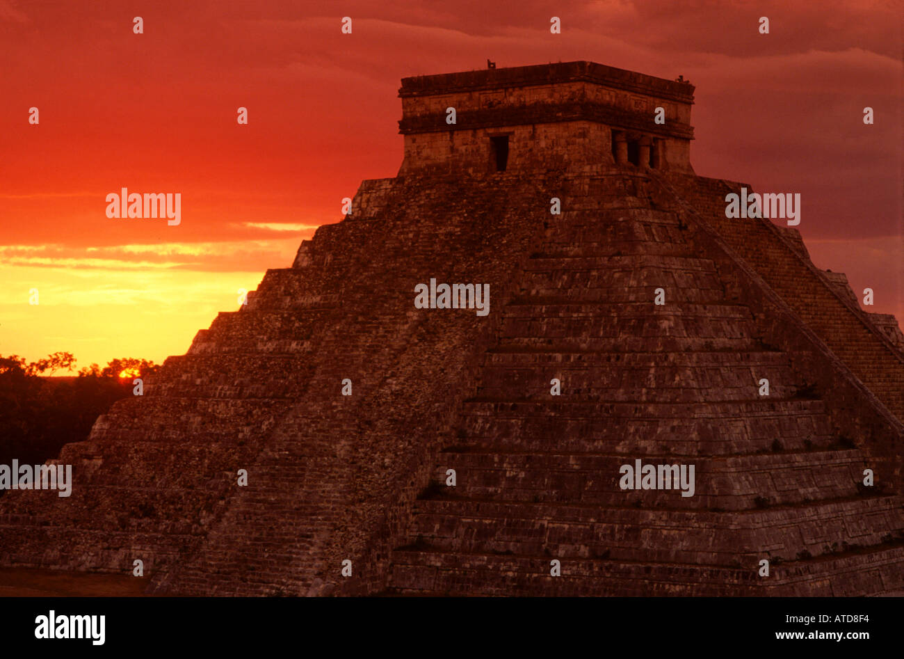 Die Sonne geht hinter der Pyramide in Chichen Itza auf der Yucatan-Halbinsel in Mexiko ist Silhouette gegen den strahlenden Farben Stockfoto