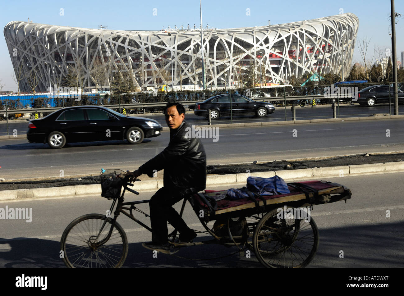 Chinesischer Mann reitet ein Dreirad vorbei Nationalstadion Peking 2008 Olympische Spiele 27 - Februar-2008 Stockfoto