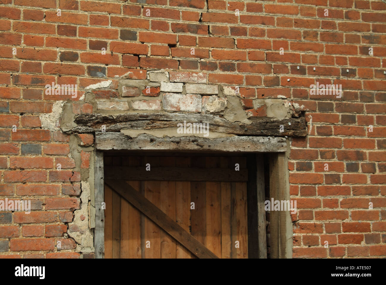 Backstein landwirtschaftlichen Gebäude mit schlechter Verarbeitung um Verfaulenden Holz lintols & Risse im Mauerwerk über Türrahmen Essex England Großbritannien Stockfoto