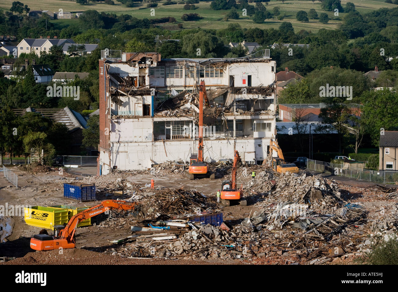 Hohe Ansicht der Abrissstelle (leere Fabrikhülle, schwere Raupenbagger arbeiten & Abrissgebäude, Schutthaufen) - Guiseley, England, Großbritannien. Stockfoto