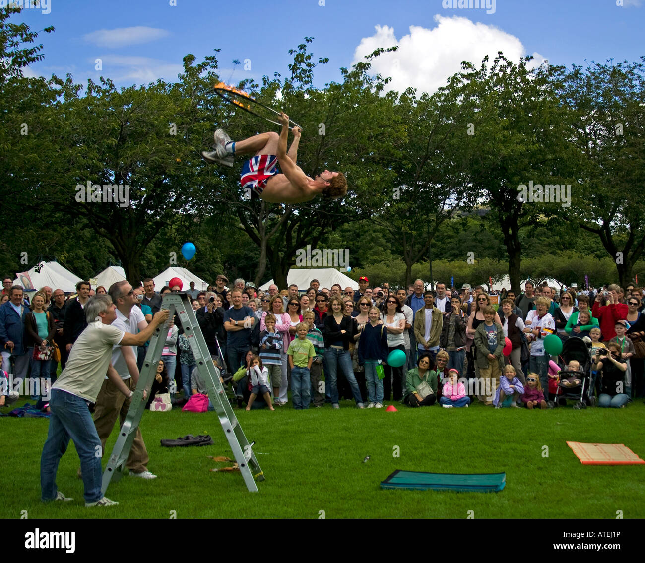 Performer springt in die Luft halten Sie einen Reifen, Edinburgh Fringe Sonntag 2007, Wiesen, Schottland, UK, Europa Stockfoto