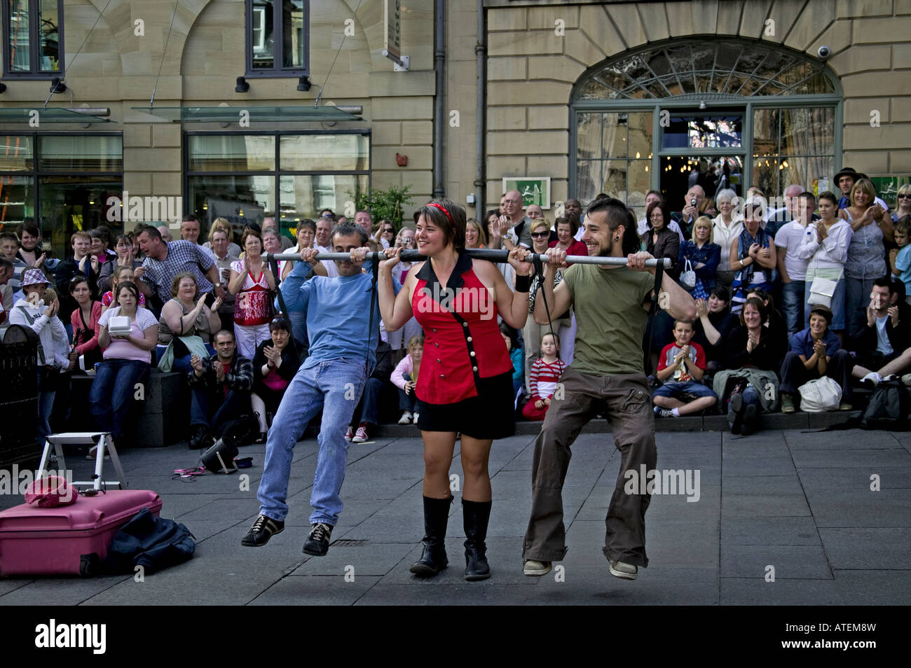 Starke Frau heben zwei Männer auf der horizontalen Pole, Edinburgh Fringe Festival, Schottland, Vereinigtes Königreich, Europa Stockfoto