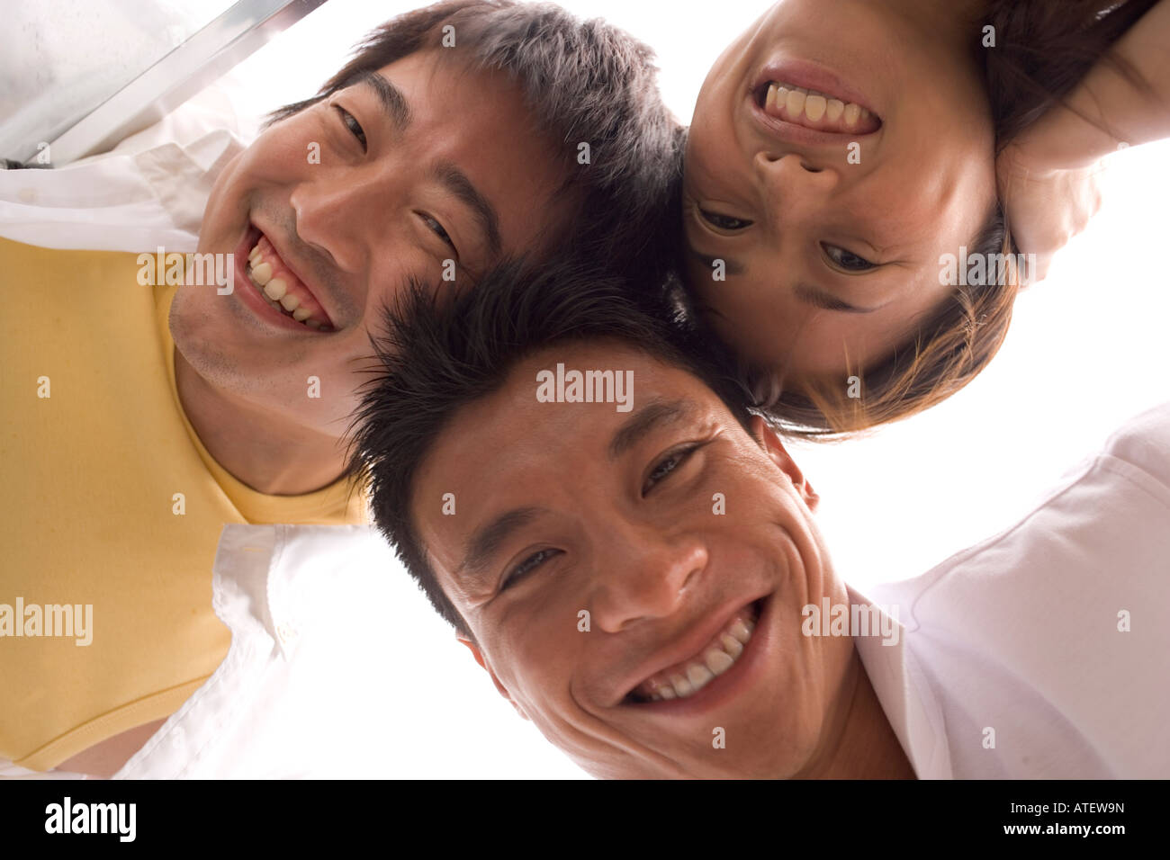 Niedrigen Winkel Blick auf zwei junge Männer und eine junge Frau, Lächeln Stockfoto
