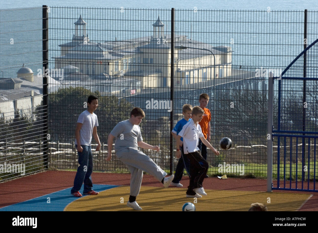 Hastings Pier mit Jungs spielen Fußball in den Vordergrund in Hastings East Sussex UK Stockfoto