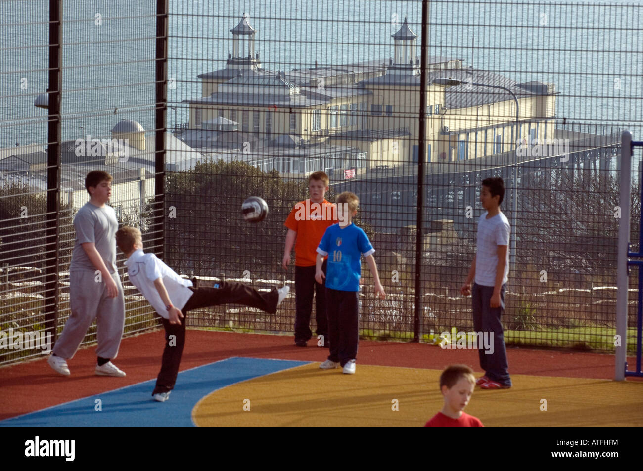 Hastings Pier mit Jungs spielen Fußball in den Vordergrund in Hastings East Sussex UK Stockfoto
