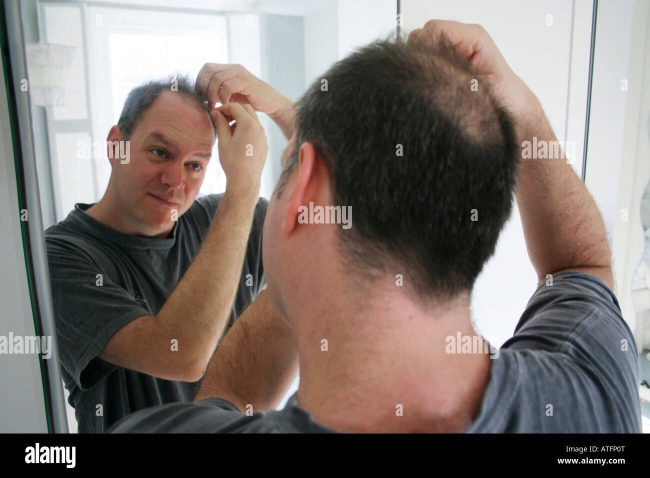 Mann Glatze im Spiegel überprüfen Stockfoto