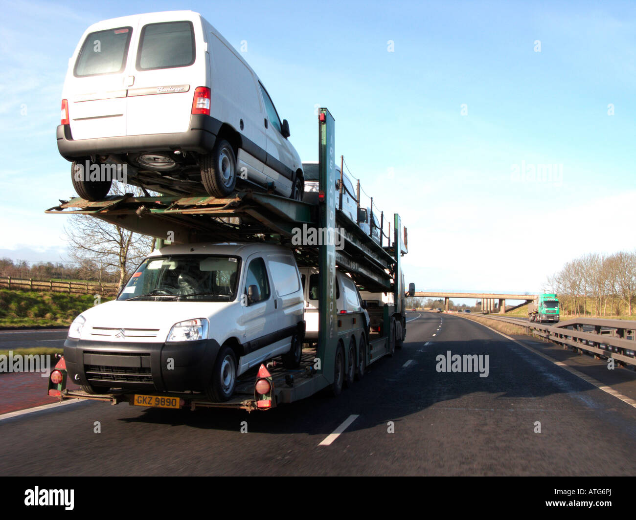 weißen Transporter auf der Rückseite des einen Autotransporter Fahrzeug entlang der Autobahn außerhalb Belfast geliefert Stockfoto
