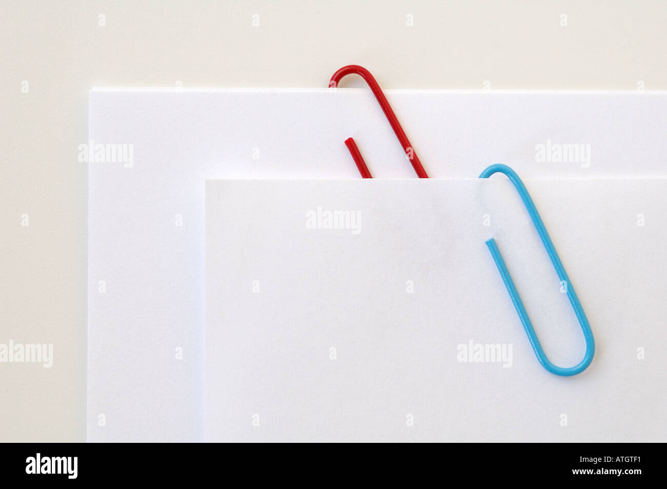 Blaue und rote Büroklammern auf weißem Papier Stockfoto