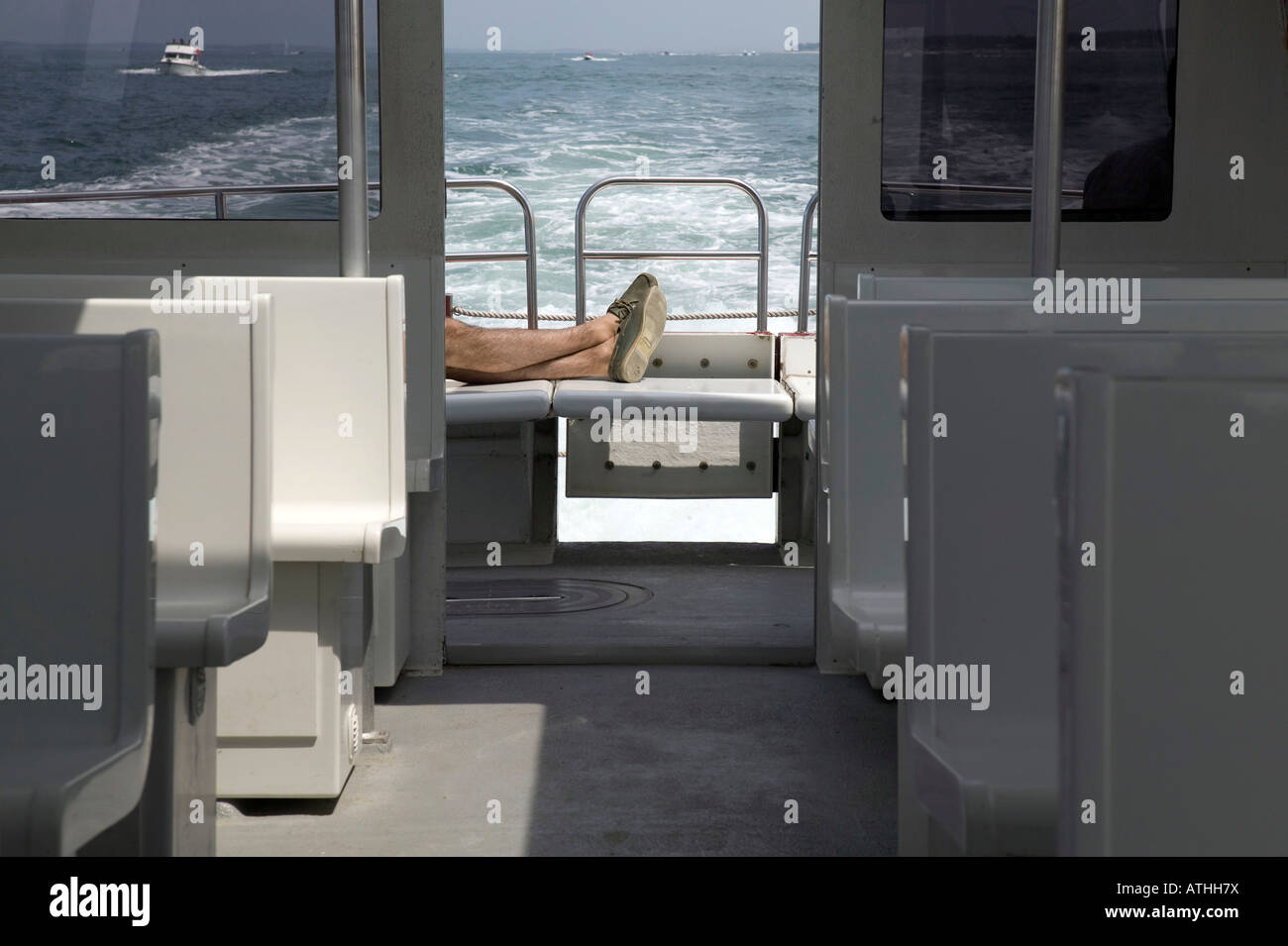 Beine und Füße des Menschen entspannt auf Boot auf dem Meer 2007 Stockfoto