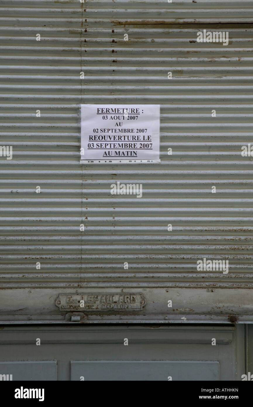 Geschlossene Metallvorhang vor einem alten Sanitär-Shop in Paris Frankreich geschlossen für den Sommer Stockfoto
