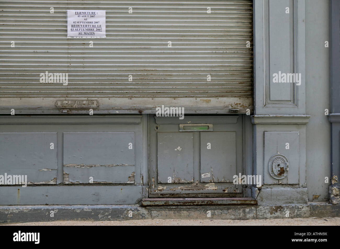 Geschlossene Metallvorhang vor einem alten Sanitär-Shop in Paris geschlossen für den Sommer Stockfoto