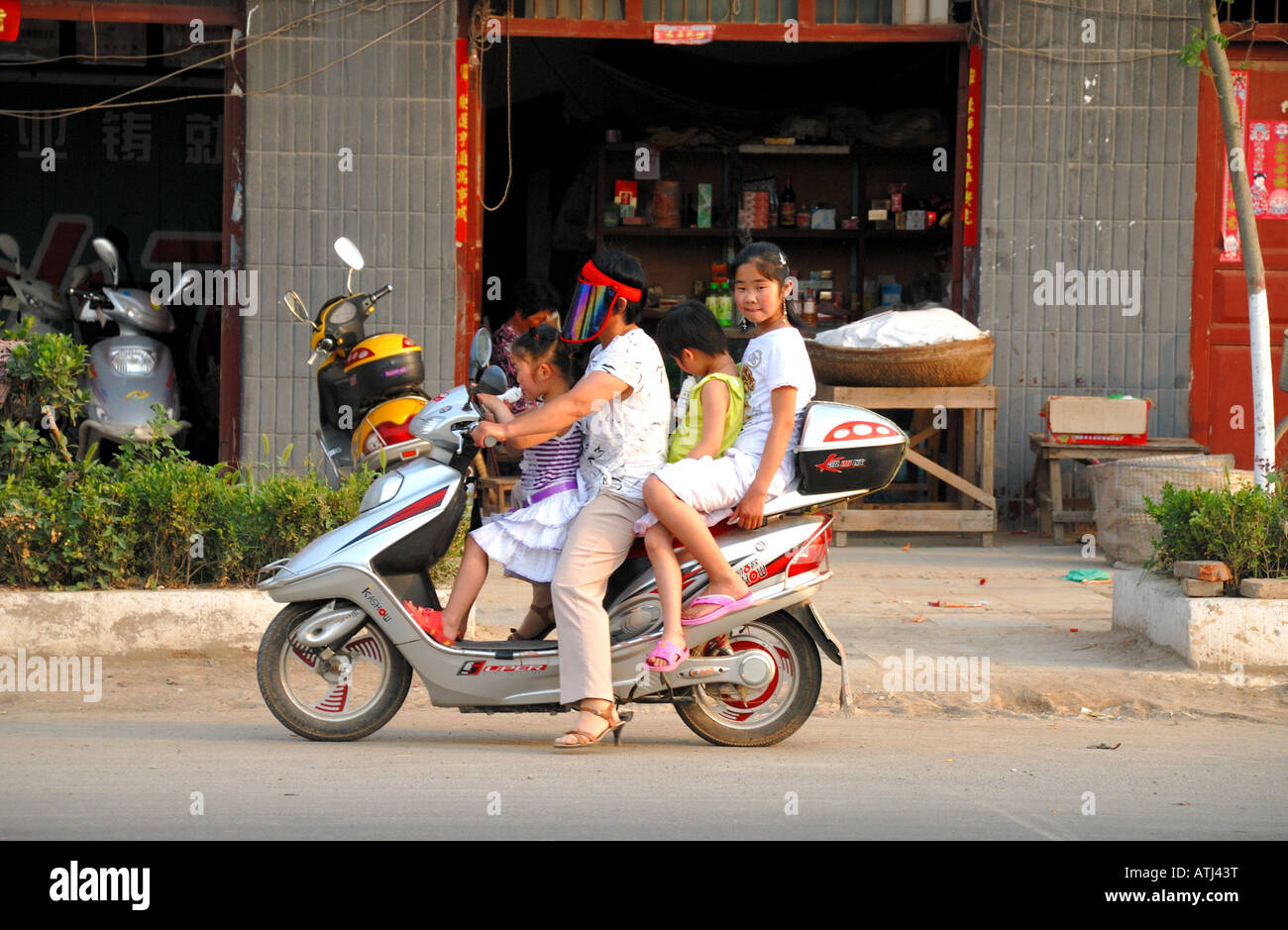 Vier Personen auf einem Motorroller unterwegs durch Taiqing Palast Quadrat Kaifeng Henan Provinz China Asien Anfahren Stockfoto