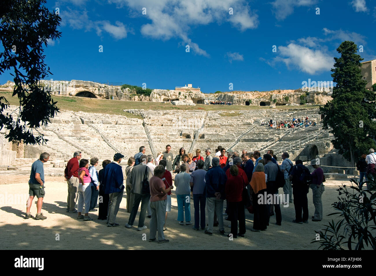 Eine Gruppe von Touristen am massiven Fels gehauenen griechischen Theater von Neapolis, Syrakus, Sizilien, die im 6. Jahrhundert v. Chr. gebaut wurde Stockfoto