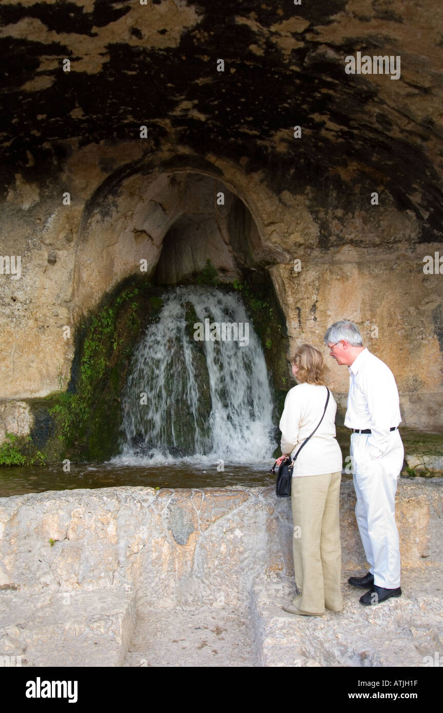 Eine Nische in den Felsen oberhalb des antiken griechischen Theaters in Syrakus, wo das Wasser von einem alten Aquädukt noch überlappend, geschnitten Stockfoto