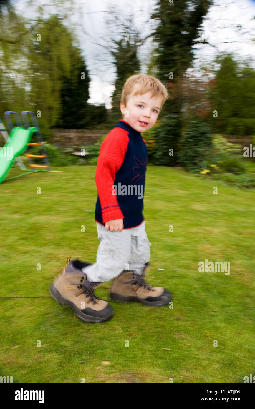 Junge 3 Jahre alt mit Erwachsenen Stiefel auf Stockfoto