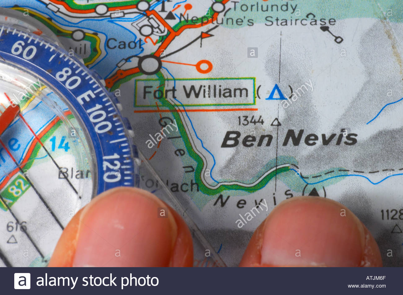 Jemand zeigt auf einer Karte von Ben Nevis und einem Kompass Stockfoto