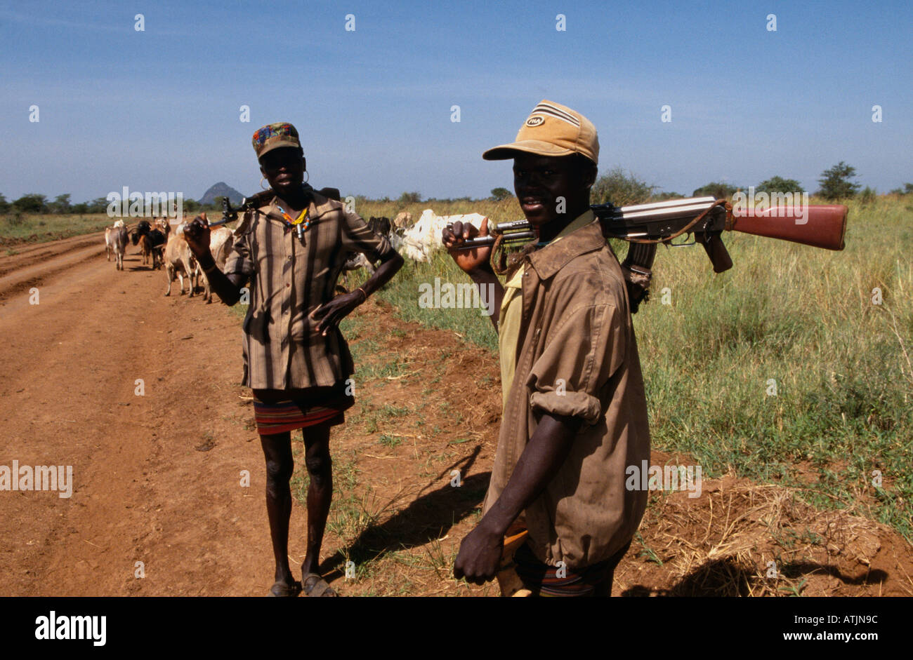 Karamoja Rinder Hirten mit Gewehren in der Landschaft, Uganda Stockfoto