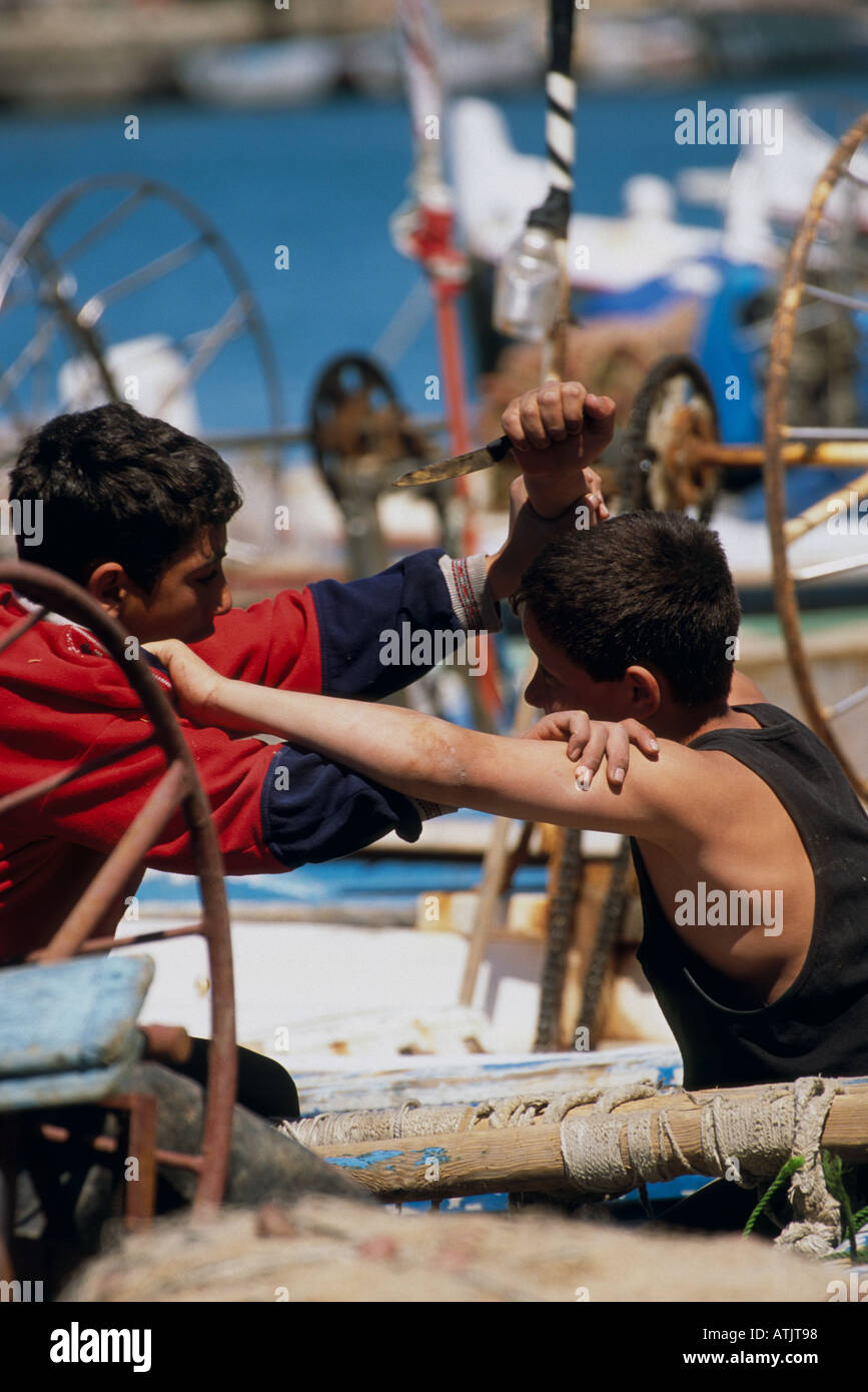 Young Boys auf Fischerboot in Kampf mit Messer. Saida, Libanon. Stockfoto