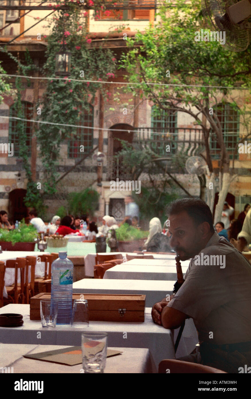Mann Rauchen einer Shisha im Gartencafé in Damaskus, Syrien Stockfoto