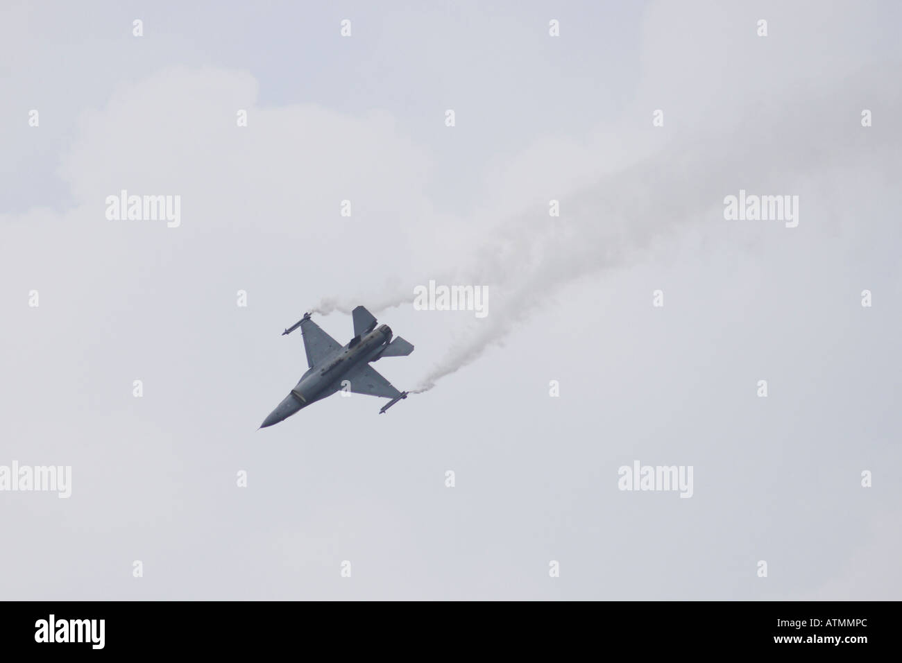 F16 Fighting Falcon fliegen in der Nähe von invertiert nachgestellte weiße Markierung Rauch Stockfoto